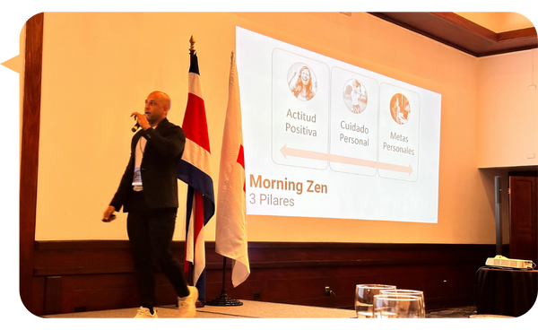 Adrián González en tarima con apoyo visual durante una presentación.